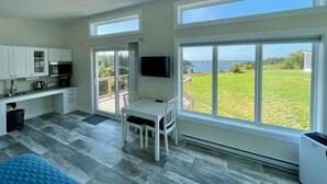 A modern kitchen with a dining area, large windows, and a view of the outdoors. - The Lookout - Executive Class, Accessible Mini Villa (Colindale)