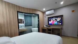 A hotel room with a bed, a TV mounted on the wall, a sink, and a toilet. - V Tour Hotel (Shanghai)