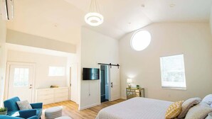 Une chambre à coucher avec un lit, une télévision, un bureau et une fenêtre.