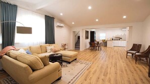Un vaste espace de vie comprenant un canapé, une table basse et une table à manger.