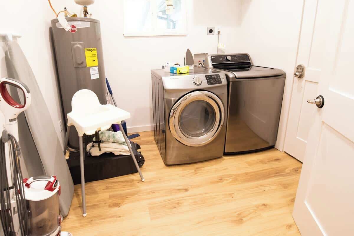 Een wasserette met een wasmachine, droger en een boiler.