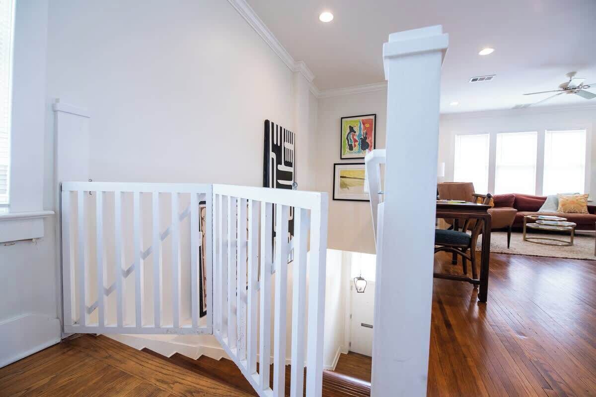 A staircase with a white railing leading to a living area with a sofa and a coffee table.