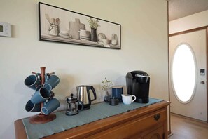 A kitchenette with a coffee maker, kettle, and mug on a wooden counter. - The Cozy Little Farmhouse (El Paso)