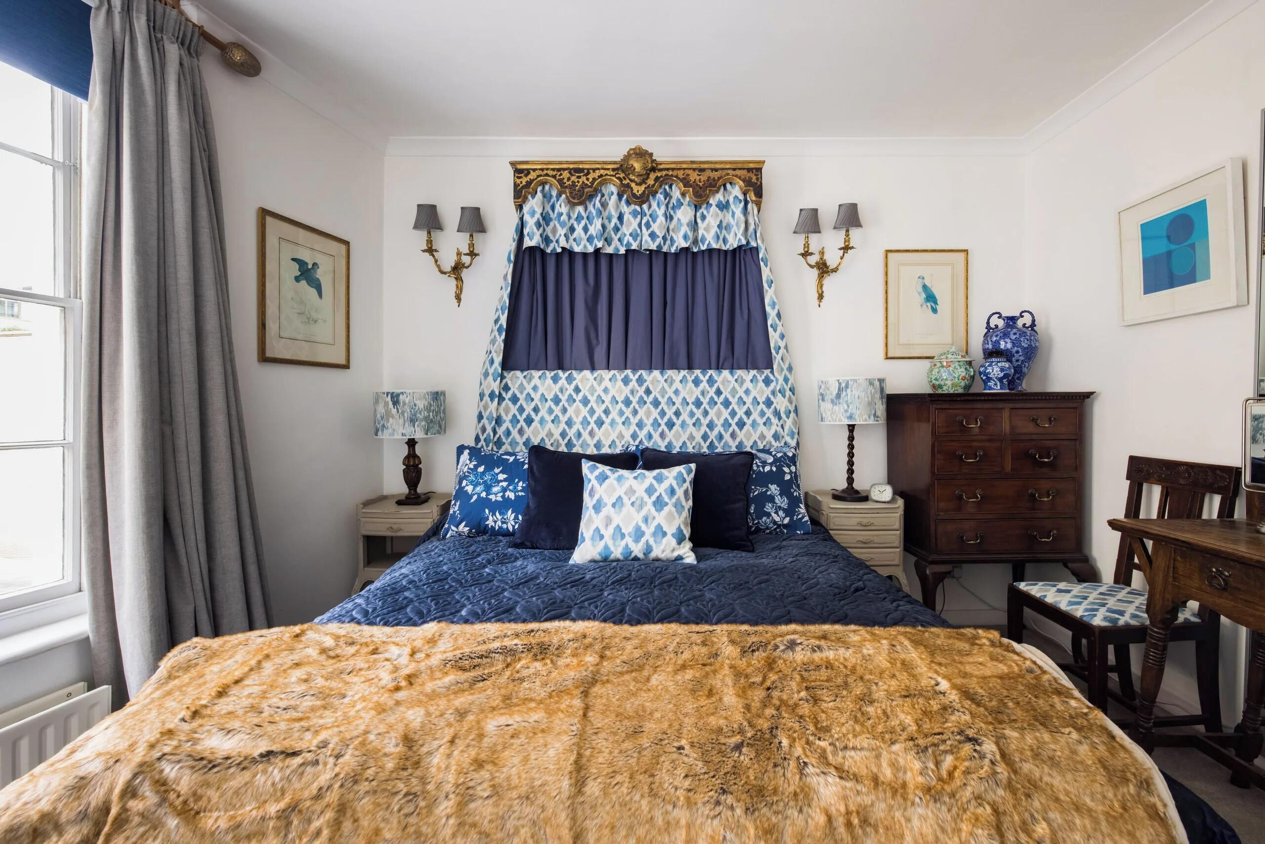 Un dormitorio con una cama grande, un aparador y una silla.