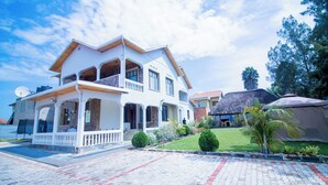 A two-story house with a balcony, a satellite dish, and a well-maintained lawn. - ArthillsBoutiqueHotel (Kigali)