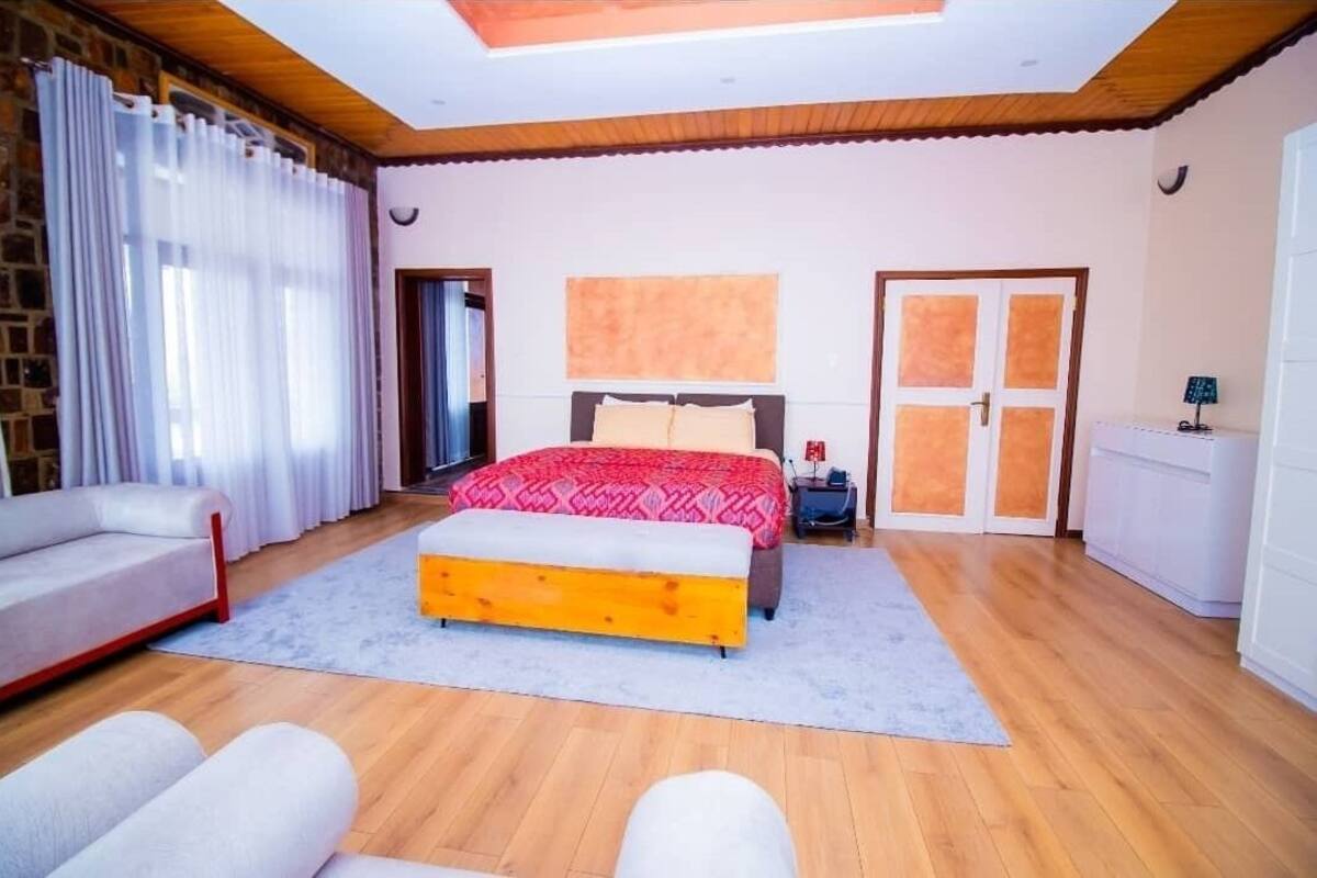 A bedroom with a bed, a sofa, a nightstand, and a wardrobe.