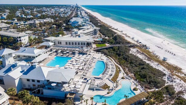 Een resort met meerdere zwembaden, toegang tot het strand en diverse gebouwen.