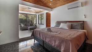 Una camera da letto con un letto, una ventola a soffitto, un condizionatore d'aria e vista sull'esterno.