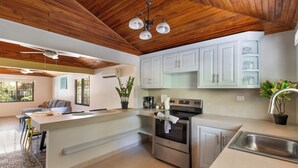 Una cucina moderna con mobili bianchi, un lavello in acciaio inossidabile e un forno integrato.