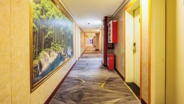 A hotel hallway with a long corridor, a large painting on the left wall, and doors on the right. - Qiyuan Yueding Business Hotel (Beijing Huilongguan East Street Subway Station) (Beijing)