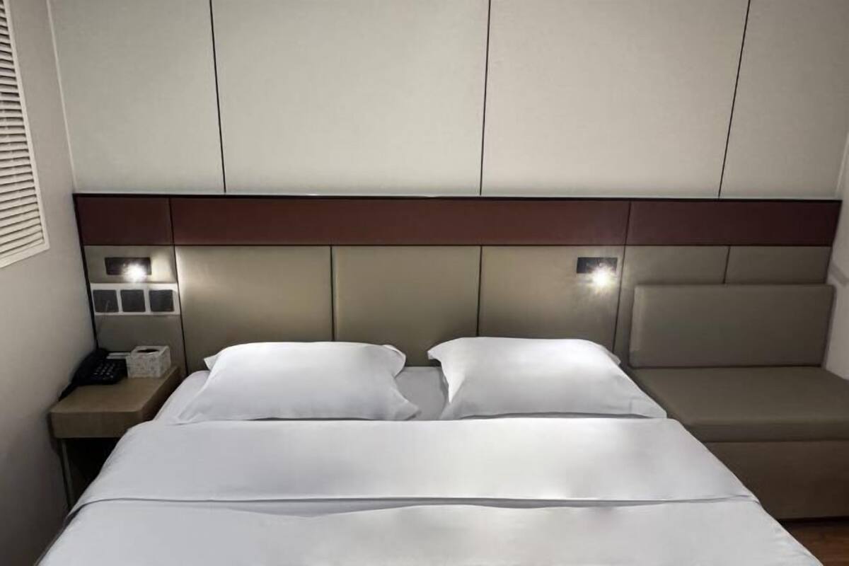 Una habitación de hotel con cama, mesita de noche y zona de estar.