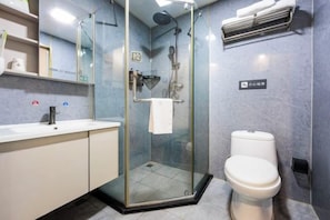 A modern bathroom with a glass-enclosed shower, a white toilet, and a sink with a mirror above it. - Qiyuan Yueding Business Hotel (Beijing Huilongguan East Street Subway Station) (Beijing)