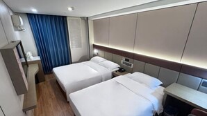 A hotel room with two beds, a desk, a chair, a small table, a trash bin, and a window with curtains. - Qiyuan Yueding Business Hotel (Beijing Huilongguan East Street Subway Station) (Beijing)