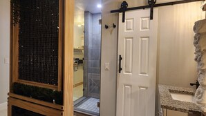 A modern bathroom with a shower, a wooden cabinet with a built-in fireplace, and a towel rack. - Cozy Apartment at Citrus Park (Tampa)