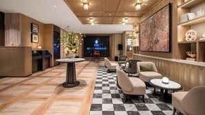 A hotel lobby with a checkered floor, round tables, sofas, and a large painting on the wall. - Manxin Hotel Suzhou Guanqian Street (Suzhou)
