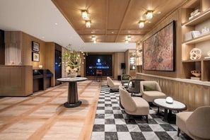 A hotel lobby with a checkered floor, seating area, reception desk, and artwork on the walls. - Manxin Hotel Suzhou Guanqian Street (Suzhou)