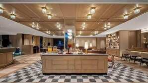 A spacious hotel lobby with a central island, checkered floor, and modern lighting fixtures. - Manxin Hotel Suzhou Guanqian Street (Suzhou)