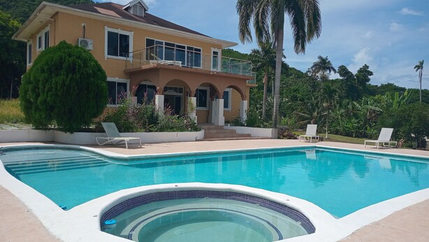 A house with a swimming pool, surrounded by lush greenery and palm trees. - Blue Seas Two Unity Hall (Montego Bay)