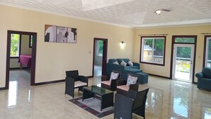 A spacious living area with a ceiling fan, a sofa set, and a coffee table. - Blue Seas Two Unity Hall (Montego Bay)
