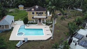 A two-story house with a swimming pool, surrounded by palm trees and a small garden. - Blue Seas Two Unity Hall (Montego Bay)