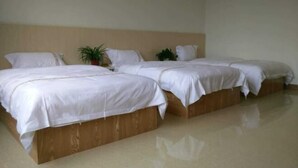 A hotel room with three beds, a wooden headboard, and a potted plant. - Huangyao Xinyi Inn (Zhaoping)