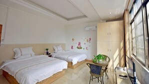 A bedroom with two beds, a small table with a plant, a chair, and a window with a view. - Huangyao Xinyi Inn (Zhaoping)