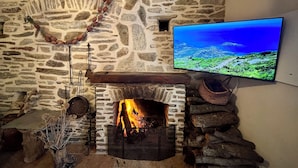 A stone fireplace with a TV mounted on the wall above it. - Casa Marelina - Fisherman's house in Centuri harbour (Centuri)