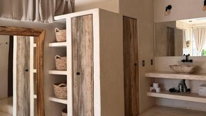 Ein modernes Badezimmer mit einem großen Spiegel, Holzschränken und einem Waschtisch mit einer Schüssel.