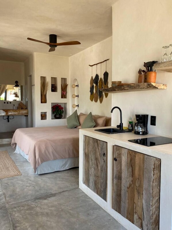 Une chambre à coucher moderne, avec un lit, une table de chevet et un ventilateur de plafond.