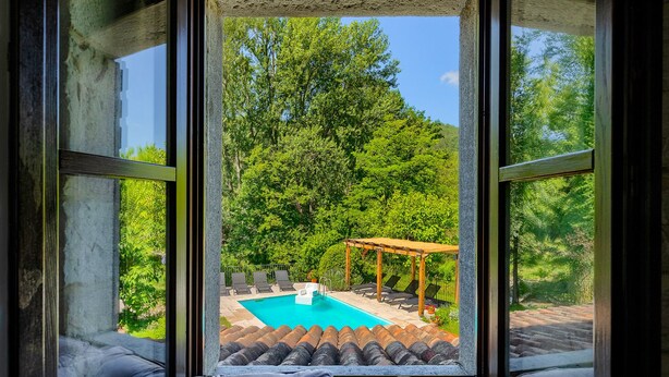 Quarto com vista para uma piscina, área de estar ao ar livre e um pergolado.