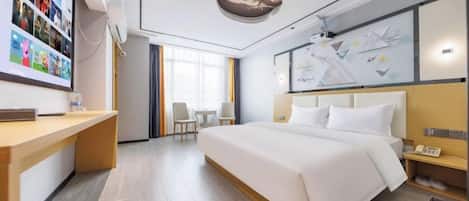 Een hotelkamer met een groot bed, een bureau, een stoel en uitzicht op het omliggende landschap.