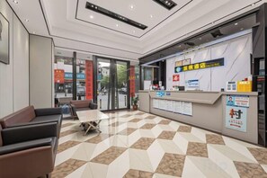 A hotel lobby with a reception desk, seating area, and a check-in counter. - chengfeng hotel(jianggao dian) (Guangzhou)