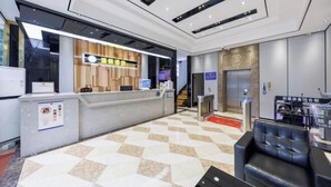 A hotel reception area with a check-in counter, a waiting area with leather seating, and an elevator. - chengfeng hotel(jianggao dian) (Guangzhou)