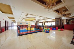 A spacious lobby with a play area, a reception desk, and a chandelier. - Lia Daocheng Resort (Daocheng County)