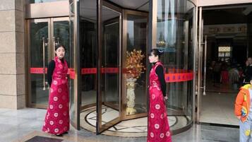 A revolving door entrance with a glass door and a red stripe.