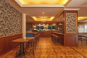 A restaurant with a bar area, wooden furniture, and patterned flooring. - Lia Daocheng Resort (Daocheng County)