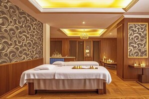 A hotel room with a large bed, a sitting area with a table, and a decorative wall. - Lia Daocheng Resort (Daocheng County)