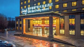 Un hotel con una entrada destacada, un paseo techado y un cartel que indica que es un resort.