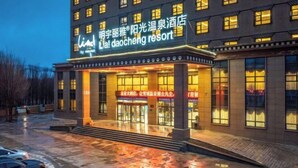 A hotel with a prominent sign, large windows, and a well-lit entrance. - Lia Daocheng Resort (Daocheng County)