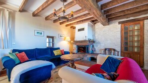 Ein gemütliches Wohnzimmer mit einem blauen Sofa, einem roten Sessel und einem Kamin.