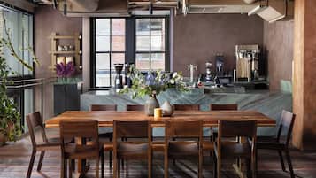 Un comedor moderno con mesa y sillas de madera, una isla de mármol y una cafetera.