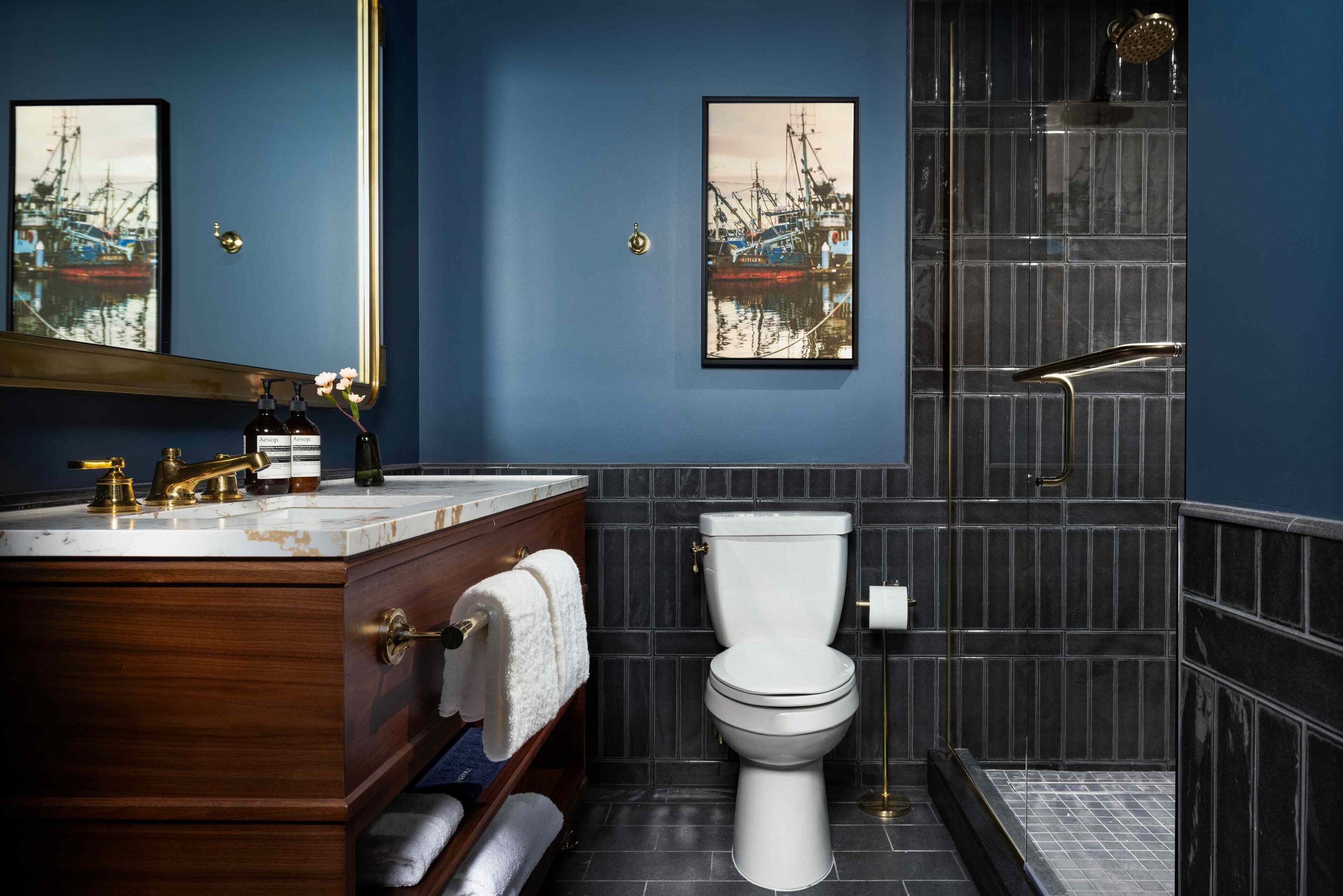 A bathroom with a wooden vanity, a white toilet, and a shower area.
