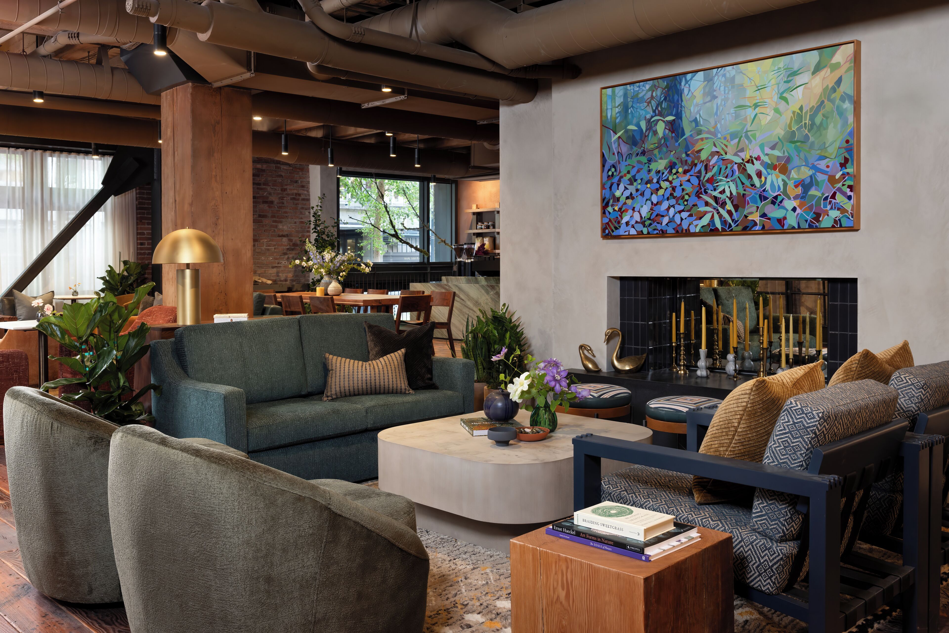 A modern living room with a fireplace, comfortable seating, and a large abstract painting.