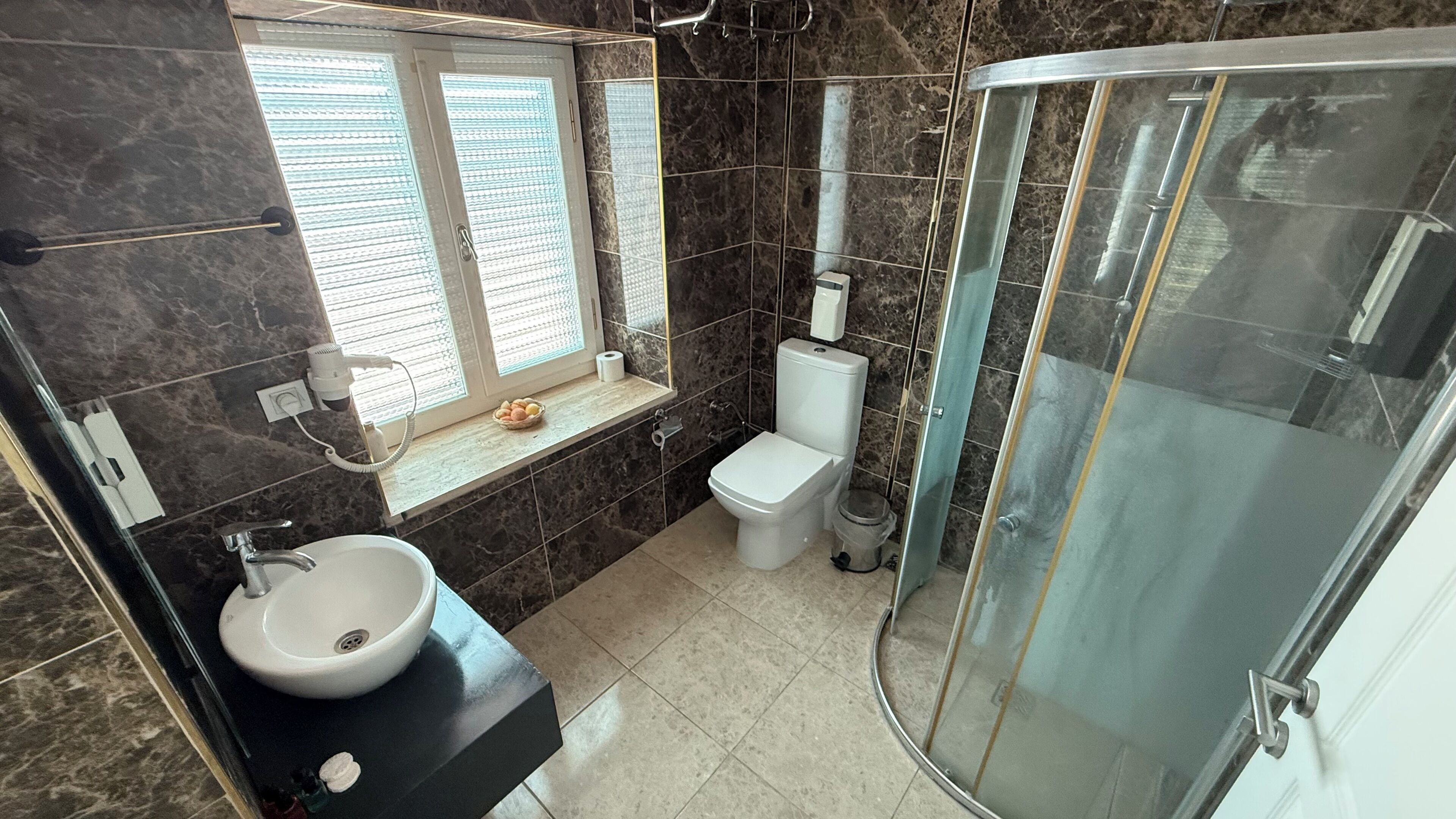 Un baño moderno con inodoro, lavamanos y ducha.