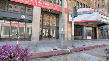 A building with a sign for condominiums for sale and a theater named 'RED ARTISTS'.