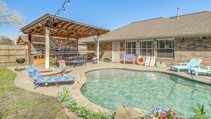A backyard with a swimming pool, lounge chairs, a barbecue area, and a covered patio. - Swim & Unwind: Pet-Friendly Home in Spring! (Spring)