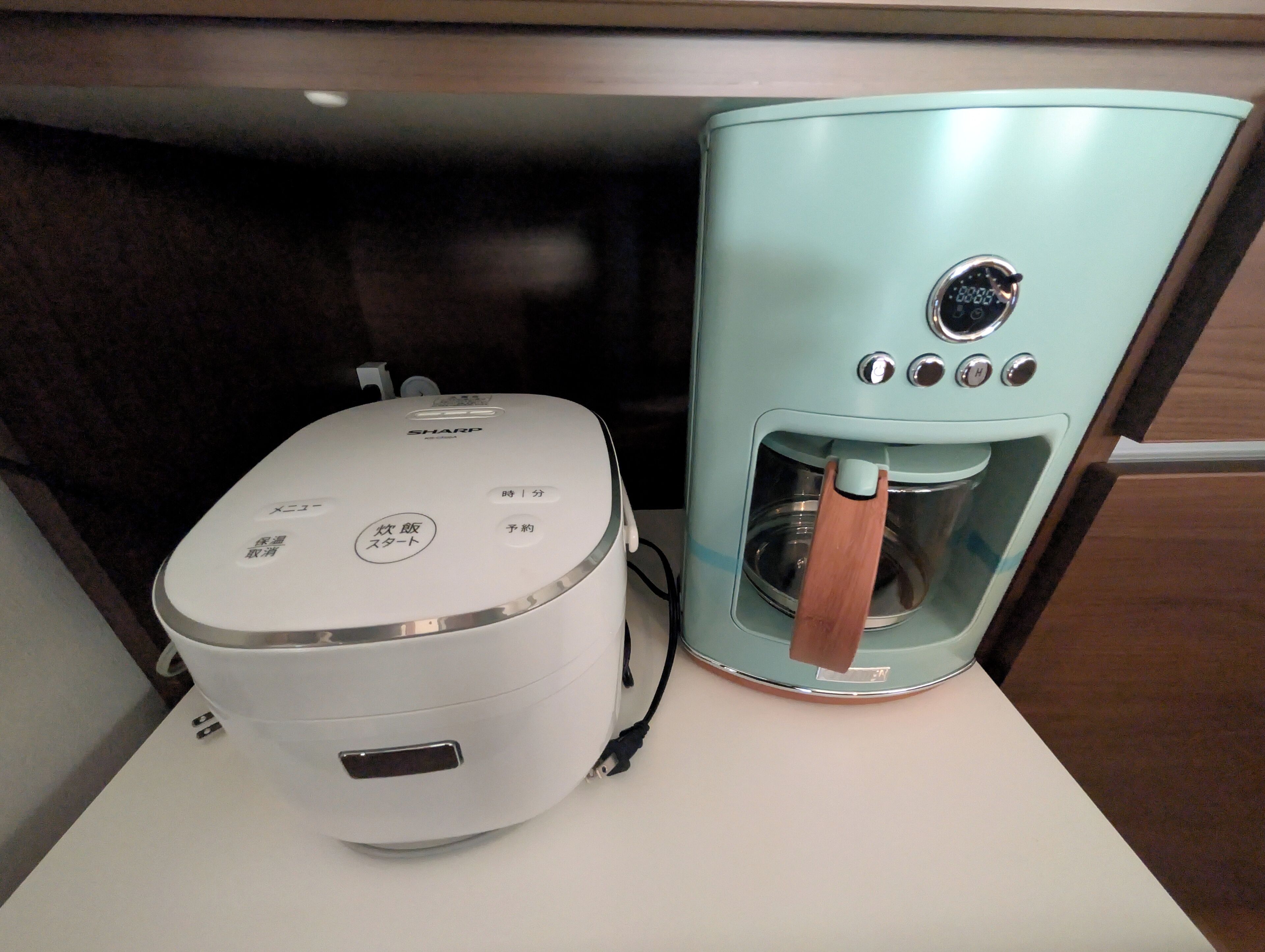 A coffee maker and a rice cooker on a countertop.