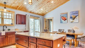 Un'ampia cucina con mobili in legno, un'isola grande e un'area pranzo con tavolo e sedie.