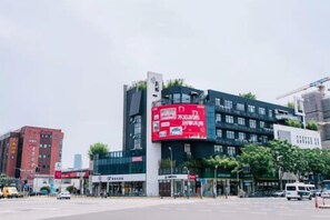 A multi-story building with a prominent red billboard on the facade. - Shanghai Shujia Hotel (Shanghai)
