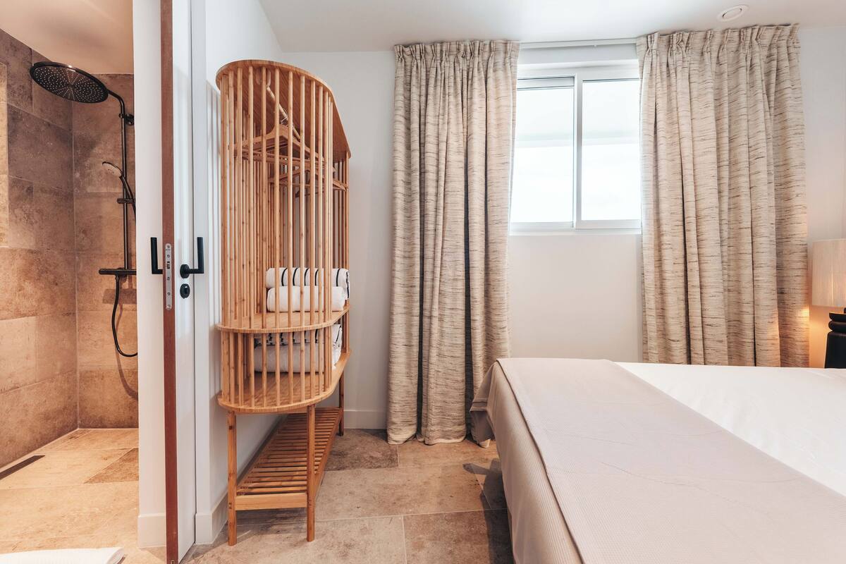 Ein modernes Badezimmer mit Dusche, einem Holckbett und einem Bett.
